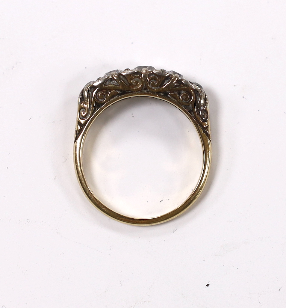 An early 20th century 18ct, plat and graduated five stone diamond set half hoop ring, with diamond chip spacers (four missing), size O, gross weight 4.3 grams.